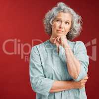 Mature woman thinking, making a decision or choice about what to wear with copy space. Confused senior caucasian female lost in her thoughts. Serious and uncertain retired lady choosing an option.