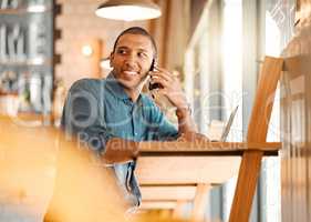 Male entrepreneur working in a coffee shop, restaurant or cafe talking on a phone call. Happy and young freelance worker doing remote work planning on a mobile conversation