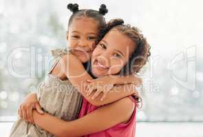 Cute, adorable and sweet girls hugging and bond with a happy and healthy childhood growing at home. Portrait of innocent and loving sisters with a bright smile, affection and relaxing in the house