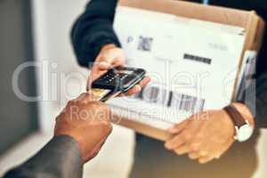 Its another convenient way to pay for deliveries. Closeup shot of a businessman using a credit card to pay for a delivery made by a courier.