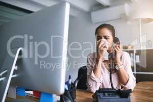 Call the doctor if your symptoms persist. a young businesswoman blowing her nose while speaking on a phone in an office.