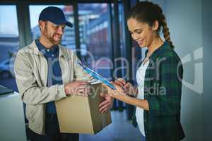 Please sign to confirm that youve received your package. a young woman signing for a package from a delivery man.