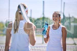 Sports women, court and conversation during tennis training for match or tournament. Friendship, together and empowerment of female athletes. Friendly talking communication with sport competitor.