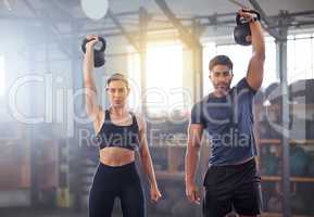 Fitness couple doing a kettlebell workout, exercise or training in a gym. Fit sports people, woman or man with a strong grip, exercising using gyming equipment to build muscles and forearm strength
