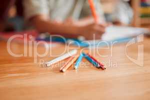 Pencils, crayons and pens on a table for creative drawing, artwork and art education in a classroom at school. Coloring supplies, equipment and tools for creativity, artist students on a desk