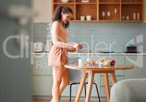 Woman making a cup of tea to relax, enjoying morning and breakfast at home, standing in kitchen. Female starting new day, preparing aromatic beverage for healthy lifestyle with fresh fruit on table.