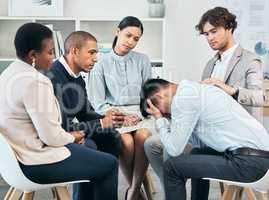 Depression, support and unity by colleagues comforting male after getting bad news at work. Community care from workers sitting together, supporting their friend after being fired or through grief