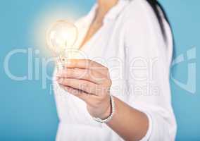 Lightbulb moment, idea and creativity with a light in the hand of a woman in studio isolated on a blue background. Closeup of motivation, innovation and development in energy, power and electricity