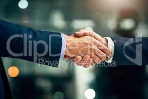 Honoring a new merger. two unrecognizable businessmen shaking hands in an office.