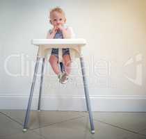 Wheres the waiter Im starving. an adorable baby girl sitting in her high chair at home.