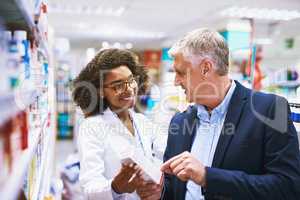 Do you need help sir. a helpful young female pharmacist helping a customer with choosing the right medication in the pharmacy.
