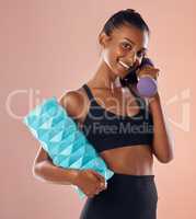 Smiling, healthy and slim female fitness instructor, holding weights and exercise equipment or tools for workout. Beautiful woman athlete with a fit body in gym sportswear against studio background