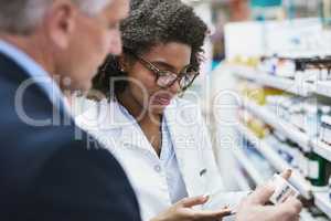 These work miracles. a helpful young female pharmacist helping a customer with choosing the right medication in the pharmacy.