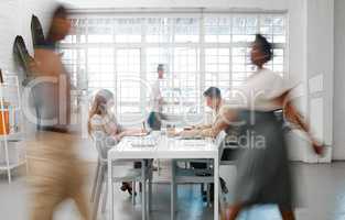 Blurred designers, marketing or freelance professionals working together in a modern office. Business men and women busy, walking and active in a creative workplace, workstation or environment