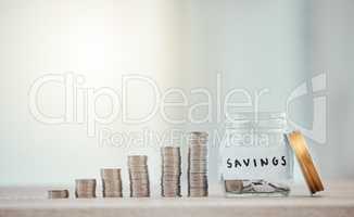 Finance, budget and saving money or coins by depositing currency, cash and pennies in a glass jar on copy space background. Closeup of piled, stacked and heaped cents for planning or future investing