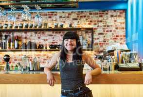 What she knows best. a waitress standing by the counter at a bar.