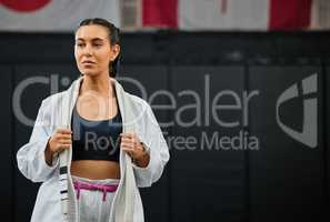 . Mma, training and martial arts with a sporty young female fighter getting ready for a fit, match or competition in her gi or uniform. Training, exercise and sparring with a woman standing in a gym.