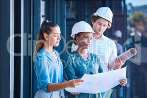 Engineer, architect or designer team looking at blueprint, design layout paper for construction building outside. Diverse city planner or business people with architecture development or floor plan