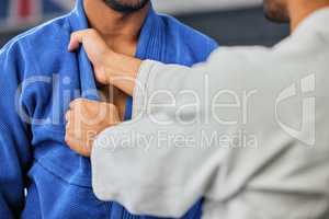 . Mma, fighting and martial arts with a teacher or instructor showing a student a grip or hold with his hands in a fight studio or sports gym. Closeup of a training workout in an exercise class.