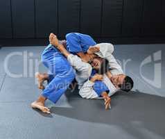 . Mma, martial arts and fighting with a student and teacher grappling on the ground during a lesson or workout in a sports studio. Training, practicing and sparring for self defense and combat sport.