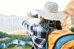 Hiking woman taking photo on adventure with phone in nature, making memories on hike and enjoying the beautiful view in the countryside on vacation. Person taking pictures of the natural environment