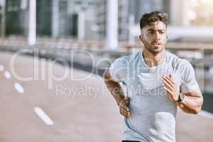 Runner running for fitness training on the street in urban city, doing cardio exercise and sport on the street. Serious, fit and sporty man jogging for health, exercising and doing routine run