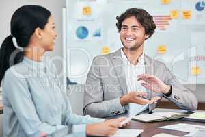 Meeting, teamwork and planning with a young business man and female colleague talking during a boardroom meeting. Discussing the vision and mission for the growth and development of their company