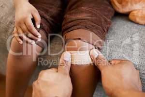 Parent childcare, knee injury and plaster on child leg after getting hurt showing care, love and support to help growth and childhood development. Hands closeup of adult applying bandage to kid