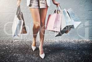 Shopping, spending and fashion with a woman carrying bags, looking for a sale or bargain and enjoying retail therapy. Closeup of a trendy, stylish and fashionable female consumer with giftbags