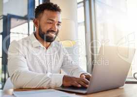 Laptop, business and technology with a corporate man at work on a computer at his desk in an office. Innovation, mission and vision with an employee working with motivation and focus toward a goal.