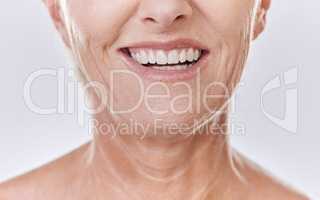 Senior woman with perfect white teeth, dental or Invisalign results and happy mouth closeup in studio. Mature model with a smile for good dentistry health insurance or excellent oral hygiene service
