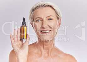 Skincare, beauty or makeup product in the hand of a senior woman holding face serum or cosmetic oil in studio on a purple background. Portrait of a female marketing, advertising or endorsing wellness