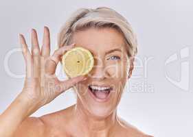 Skincare, wellness and face of mature woman with wrinkles holding lemon with nutrition, vitamins and health. Portrait of happy senior lady with fruit and healthy, organic and fresh self care routine.