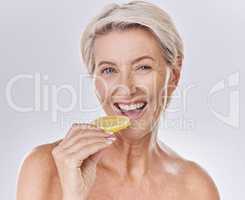 Health, nutrition and wellness of a mature woman happy in her aging skin care, beauty and face. Portrait of an old female model with a lemon promote a healthy natural lifestyle for skincare benefits
