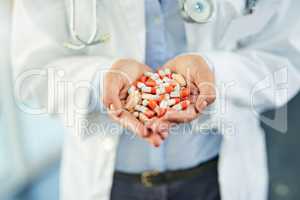Pills for prevention and cure. Closeup shot of an unidentifiable doctor holding a variety of pills in her hands.
