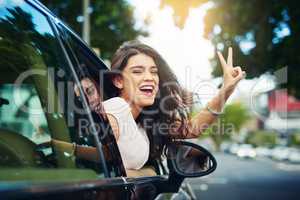 Spreading her positivity in the city. an attractive young woman celebrating her new car.