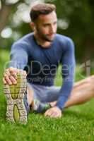 Stretch properly to avoid injury. a handsome young male runner warming up before his workout.