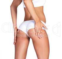 Its firm to the touch. Studio shot of an unrecognizable young woman in her underwear posing against a white background.