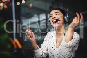 Overjoyed. Another satisfied customer. an attractive young businesswoman working late in a call center.