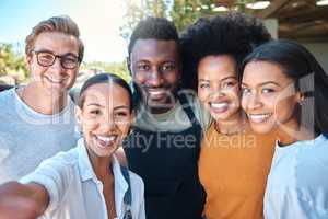 Portrait of diverse friends taking a selfie, bonding and enjoying their freedom outdoors together. Young group having fun, smiling and looking happy on a weekend, hanging out and loving friendship