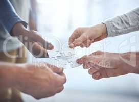 Putting their vision together. Closeup shot of a group of unrecognisable businesspeople holding puzzle pieces together.