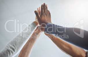 Teamwork for the win. Closeup shot of a group of unrecognisable businesspeople high fiving in an office.