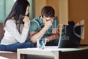 All our accounts have been cleared out. a stressed couple sitting in front on their laptop at home.