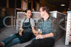Laughing couple, wine tasting date and drinking alcohol with glasses in remote farm distillery, winery estate or countryside. Happy, flirt or bonding interracial man and woman enjoying vineyard drink