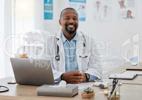 Doctor, medical healthcare worker and male physician at hospital or clinic working with stethoscope and electronics. GP man on laptop reading emails, patient records and documents in covid pandemic