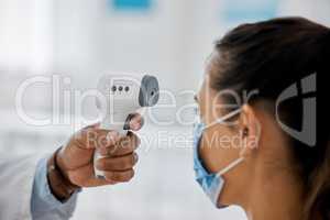 Compliance, healthcare and covid with a doctor scanning a patient temperature with infrared thermometer, checking for a fever. Concerned woman suffering from corona, flu or cold in exam or consult