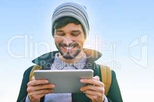 Connect and go places. a young man using a digital tablet outdoors.