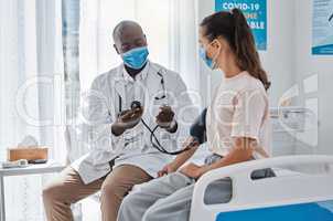 Doctor, blood pressure and healthcare medic checking womans hypertension levels on the hospital bed. People, healthy or sick patient doing medical test in covid 19 mask for pandemic safety protocol