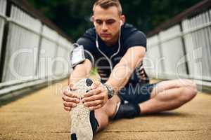 Prepare to knockout your goals. a sporty young man stretching before a run outdoors.