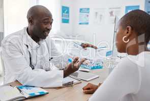 A doctor giving patient hospital information at a clinic and explaining medical benefits to a woman in his office. African American GP or healthcare professional having a discussion with a female